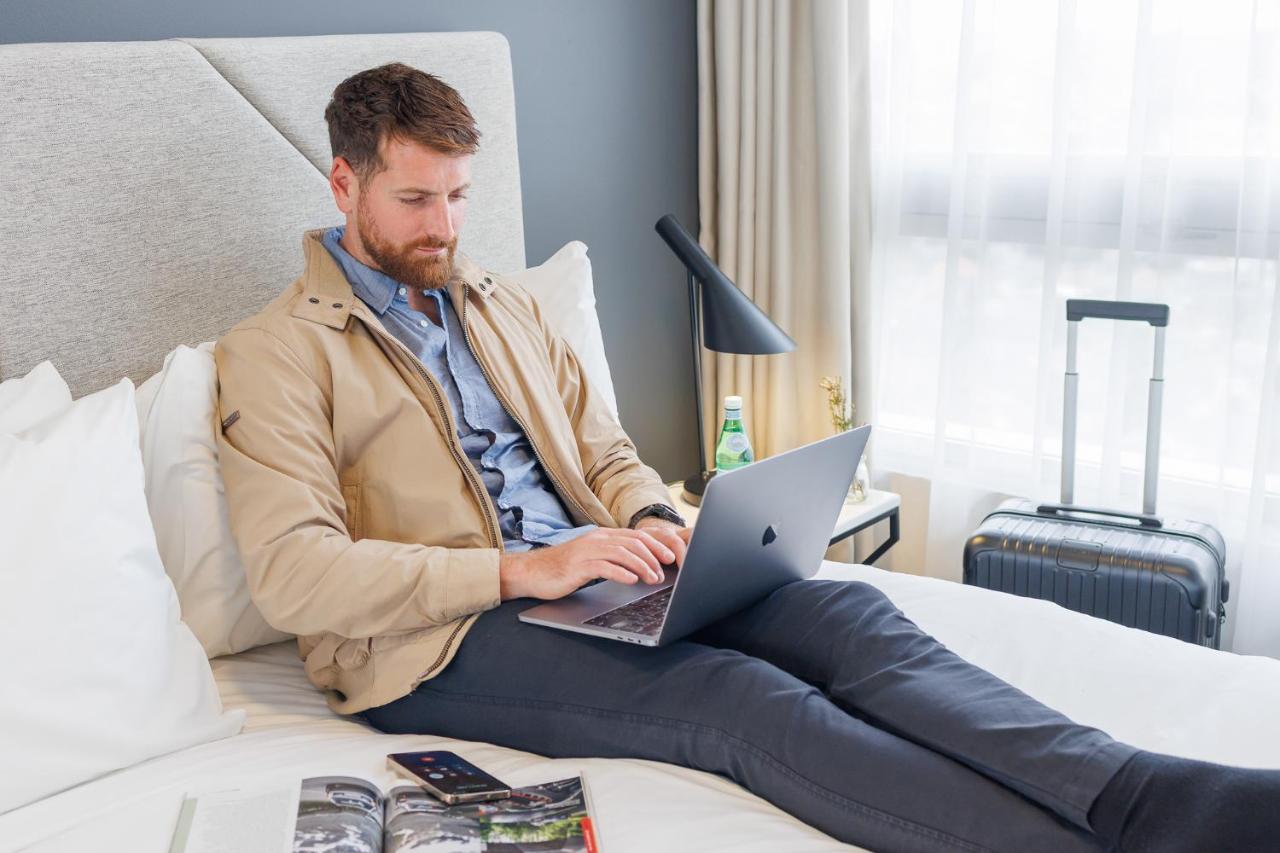 Meriton Suites Zetland Sydney Exterior foto A business traveler working on a laptop in a hotel room
